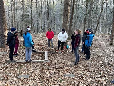 people stand in the woods in a circle